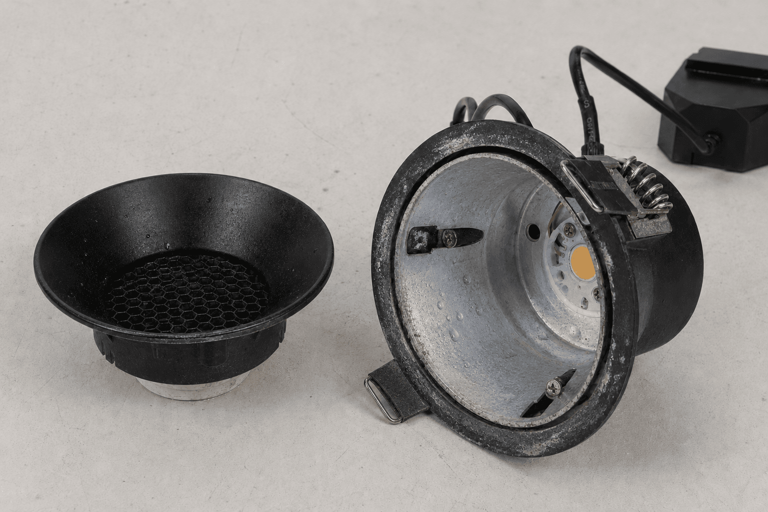 Corroded LED downlight housing showing material and surface deterioration